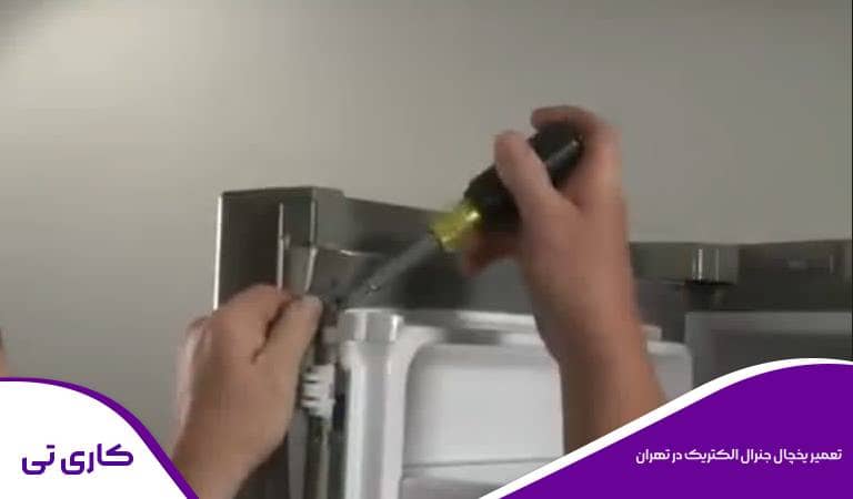 یخچال جنرال الکتریک توسط تعمیرکار در تهران در حال تعمیر است.